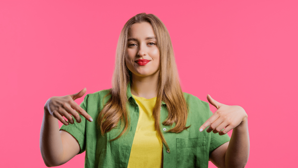 woman pointing down in pink background