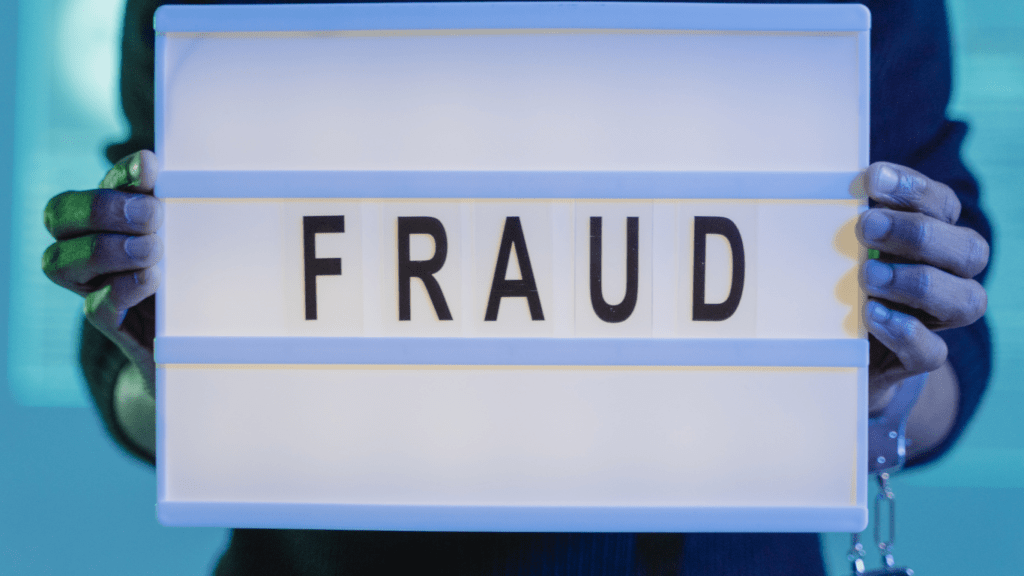 a man holding a sign about fraud