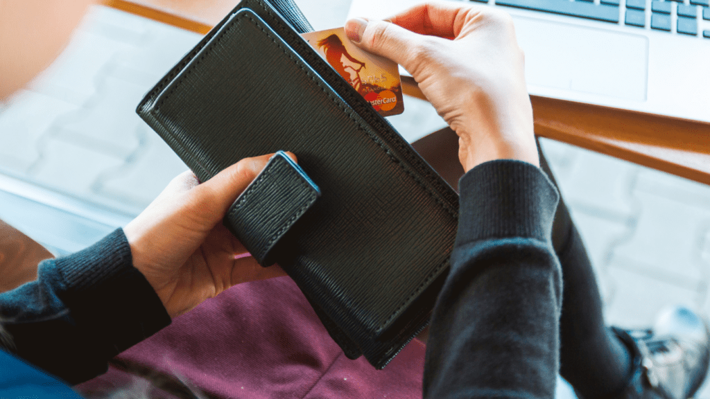 a man holding it's card into his wallet